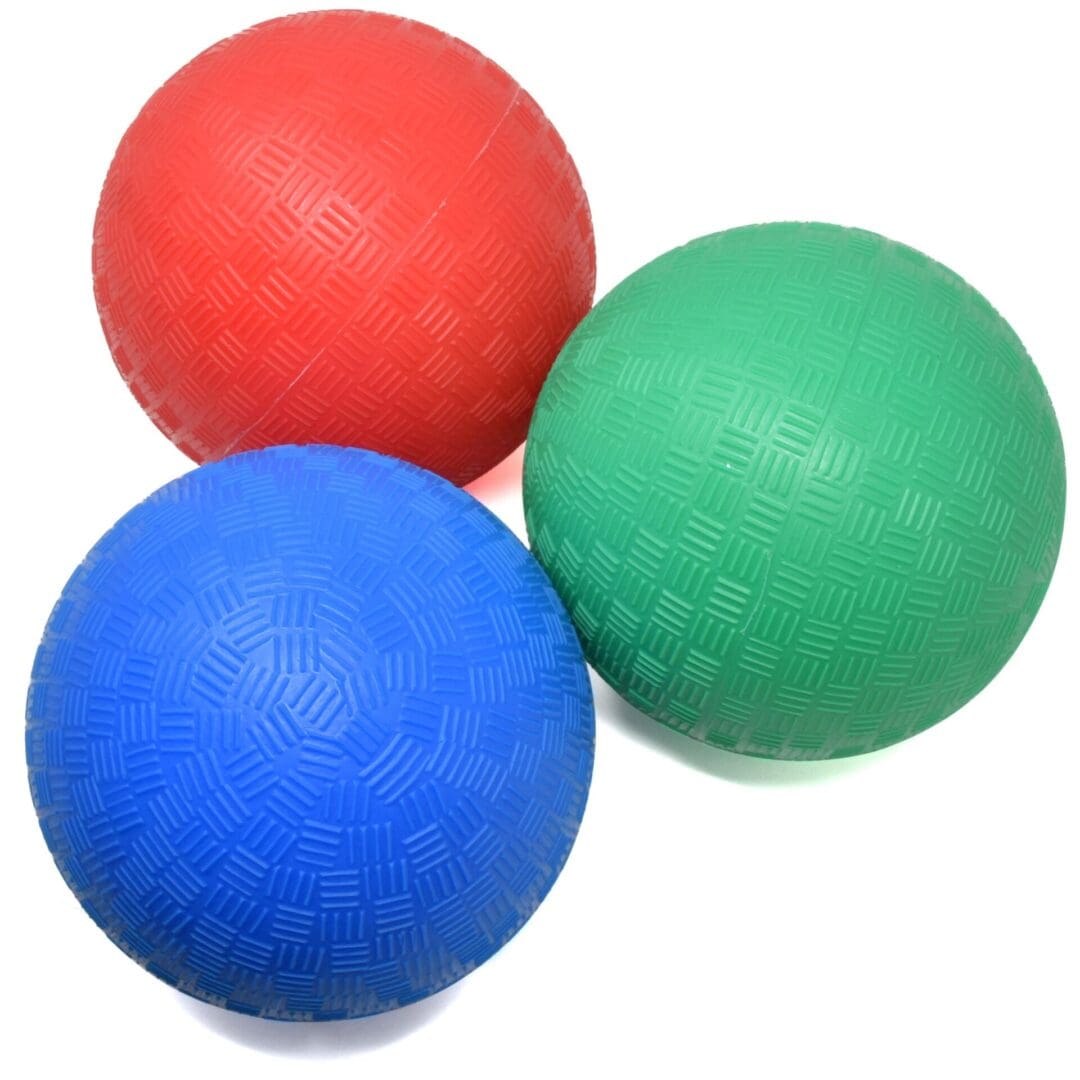 Three balls are laying on the ground in a group.